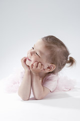 Happy and Smiling Little Blond Child Posing in Pink Dress against white Background