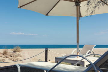 White sunbeds on your private beach waiting for you