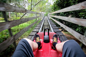 Rail downhill on a trolley to the Datanla waterfall in Vietnam. Foot passenger in sneakers on the trolley track 