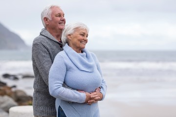 Fototapeta na wymiar Senior couple embracing each other on the beach