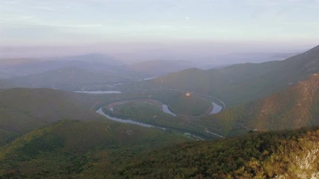 Aerial video of a meandering river under a mountin