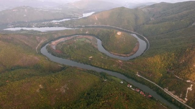 Aerial video of a meandering river under a mountin