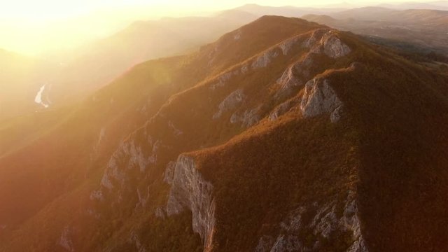 Aerial view, flight over a bautiful sunny mountain forest landscape with sunset