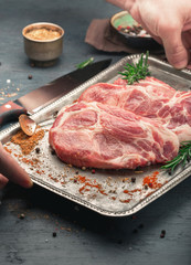 Male hands holding tray with raw steaks for grilling