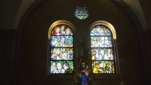 Multicolored stained glass church window illustrated Bible stories. stained glass windows with religious motifs. Manila Cathedral interior, Intramuros. 4K video, Philippines