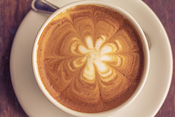 A Cup of coffee latte on wooden table top view