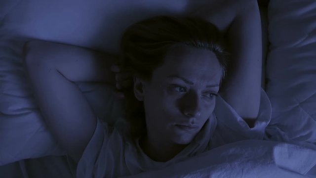 Insomnia concept. Woman in bed at night can not sleep