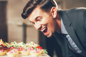 Man Having Great Desire to Eat Tartlets in Buffet