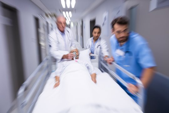 Doctor and nurse pushing emergency stretcher bed in corridor