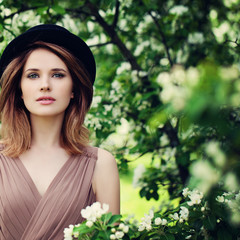 Fashion Model Woman in Spring Flowers Garden Outdoorswith Flower