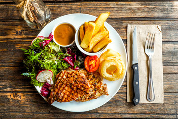 Top view Grilled pork steak with vegetables salad and french fri