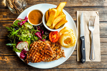 Top view Grilled pork steak with vegetables salad and french fri