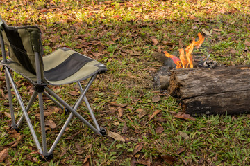 chair placed near fire camping