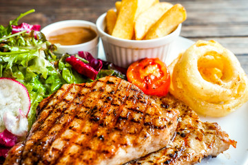 Grilled pork steak with vegetables salad and french fries