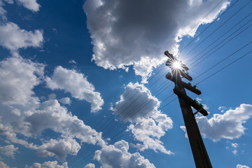 Old telegraph pole, profiled on sky with cumulus clouds, on a bright, sunny, day