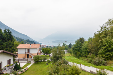 Fototapeta na wymiar Houses at the coast of Lake Of Santa Croce in Dolomite Alps, Veneto region, Italy.