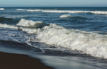 Khalaktyrsky beach with black sand. Pacific Ocean washes Kamchatka Peninsula.