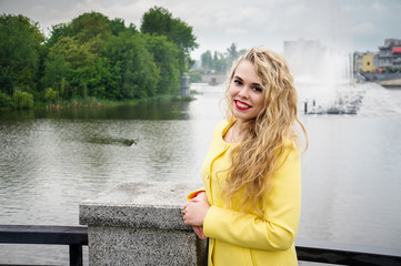 Blonde in a yellow dress against the backdrop fountain