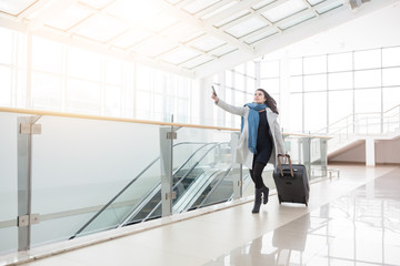 Young business woman with suitcase running to catch the plane