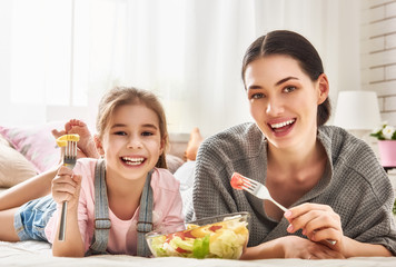 Mother and daughter eating salad