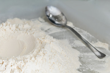 Flour and metal spoon, background