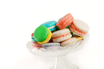Colorful  variety of macaroon cookies in a glass tray isolated on white background. 