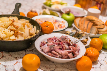 Country dinner with roast potatoes, smoked fish, bread, coleslaw and fruits
