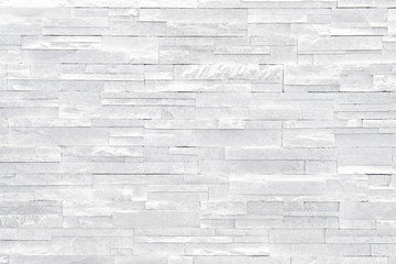 Fototapeta premium White stone wall background. Stacked stone tiles are often used in interior design decors as accent wall. Use this gray texture in graphic design to create a wallpaper, background, backdrop and more!