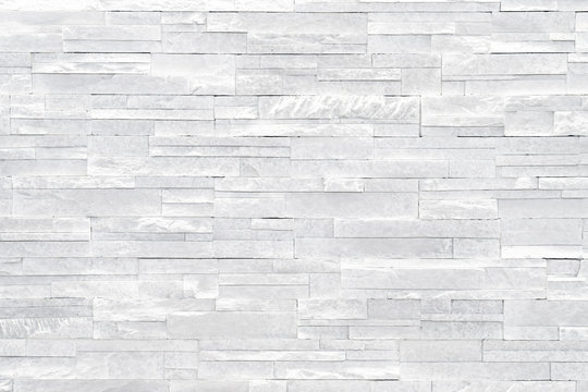 White stone wall background. Stacked stone tiles are often used in interior design decors as accent wall. Use this gray texture in graphic design to create a wallpaper, background, backdrop and more!