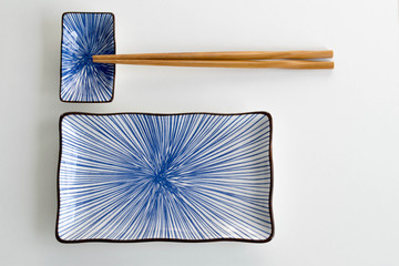blue ceramic sushi plates and carved wooden chop sticks