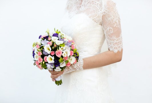 young bride  holding a bouquet of pink and blue flowers