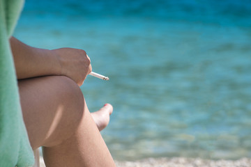 Woman with a cigarette near sea