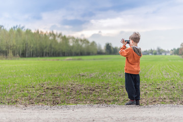Young boy taking a a picture with smartphone
