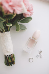 Fototapeta na wymiar Wedding details: bouquet, ring, earrings and perfume.