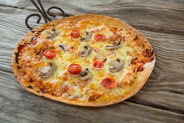 Italian pizza served in a pan on a wooden plank
