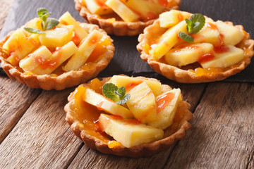 Tartlets with pineapple, jam and mint close-up. horizontal