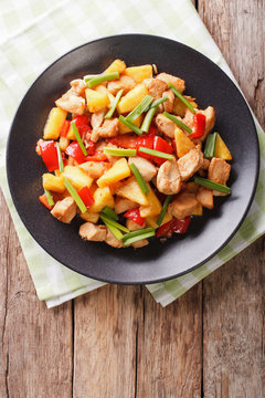 Chinese food: fried chicken with pineapple in sweet and sour sauce close-up. vertical top view