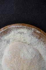 Pizza dough ball on a wooden tray