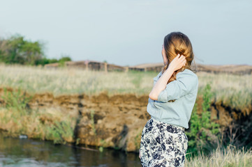 girl looks into the distance, hand touching hair
