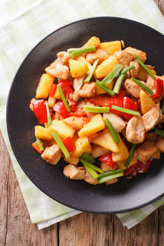 roasted chicken breast with pineapple and vegetables in sweet and sour sauce. vertical top view