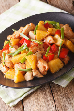 fried chicken with pineapple and vegetables in sweet and sour sauce close-up. vertical