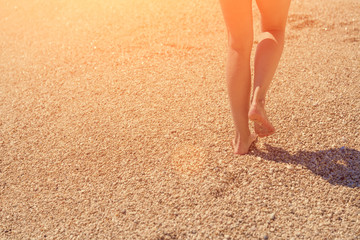 Female feet emerging from the sea  in the sunlight