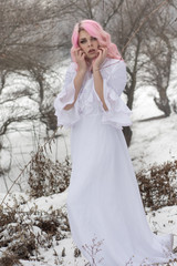 Fototapeta na wymiar Winter portrait of a yong sensual girl in white dress at the snow forest.