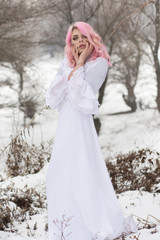 Fototapeta na wymiar Winter portrait of a yong sensual girl in white dress at the snow forest.