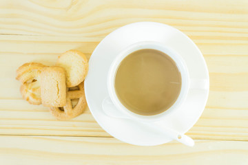 Coffee cup and candy on wood table background.