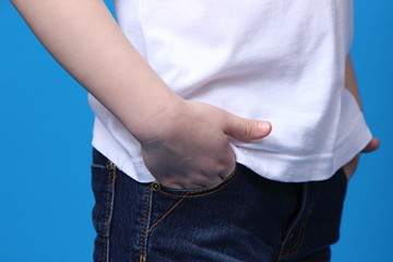 girl put her hands in the pockets of his jeans. isolated on blue background