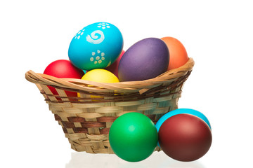 Basket filled with colorful Easter eggs on a white background