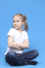girl sitting cross-legged on a blue background