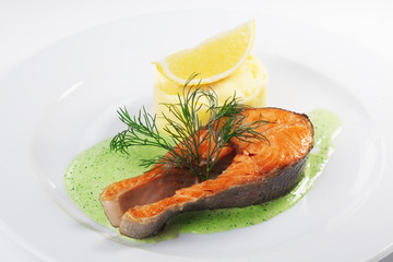 Salmon Steak with mashed potatoes on a plate isolated white background pesto