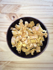 Crispy deep fried wonton in black bowl on wood background